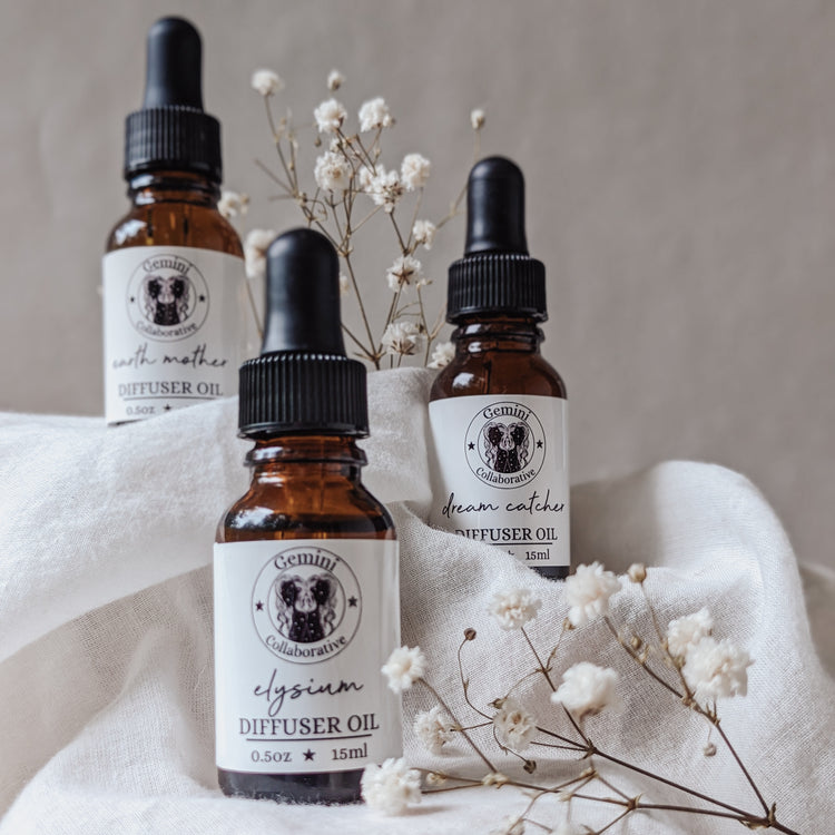 Photo of three half ounce glass bottles of diffuser oils arranged in front of dried florals