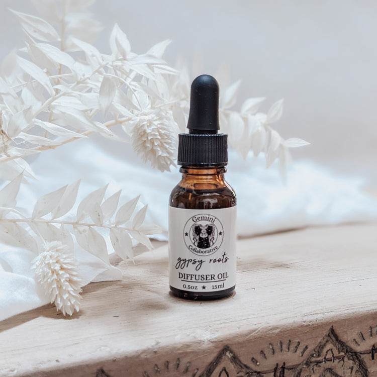 Photo of diffuser oil in half ounce glass bottle with glass pipette in front of floral arrangement