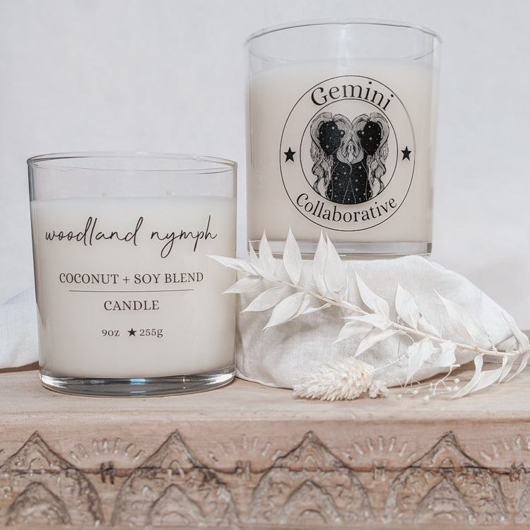 Photo of two candles side by side with dried florals in the background.