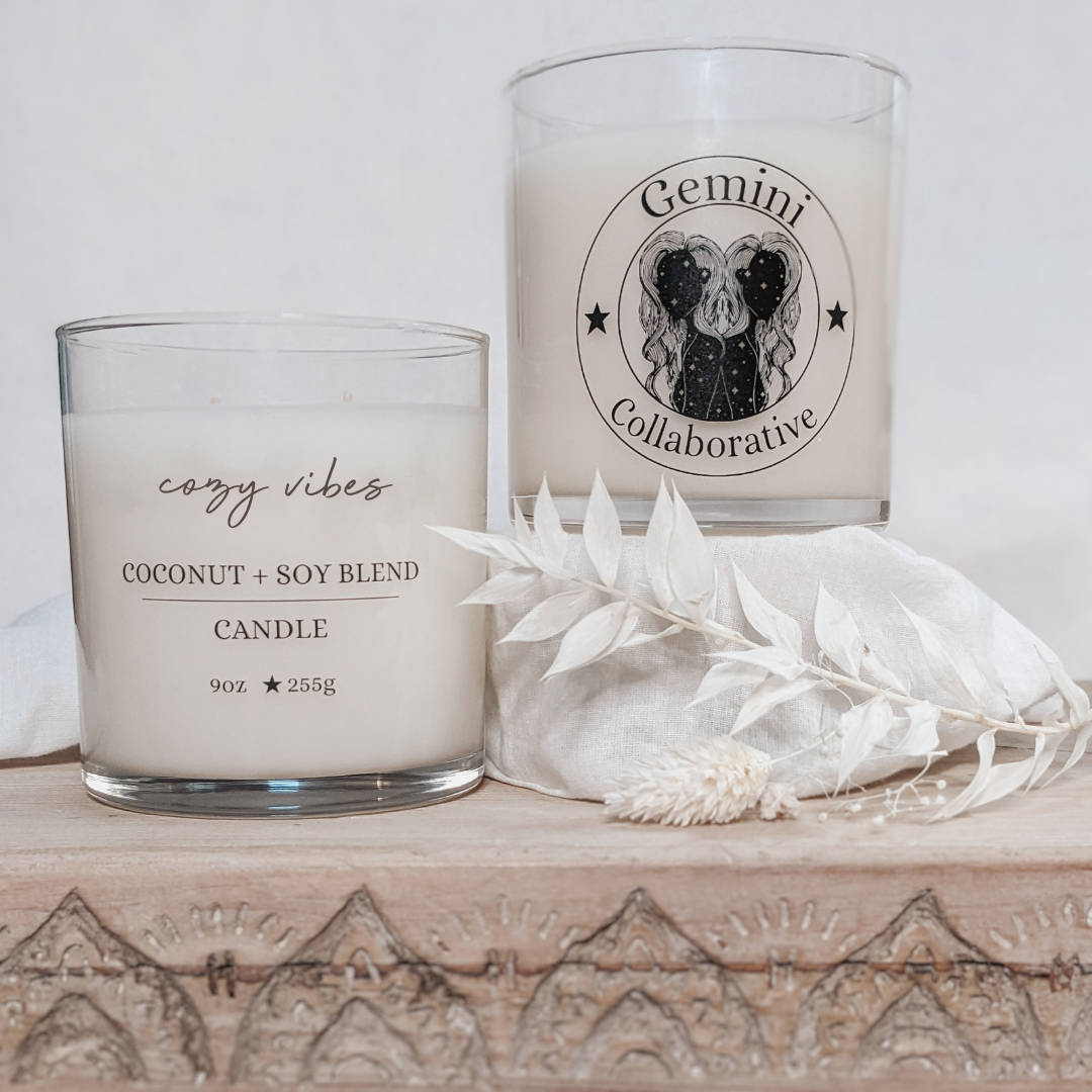 Photo of two candles side by side with dried florals in the background.